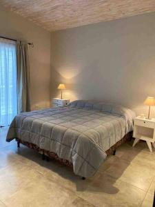 - une chambre avec un grand lit et 2 tables avec des lampes dans l'établissement Best Logde Valle de Uco , Mendoza .Casa Calma, à Vista Flores