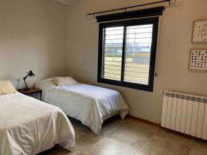 ビスタ・フローレスにあるBest Logde Valle de Uco , Mendoza .Casa Calmaのベッドルーム1室(ベッド2台、窓付)
