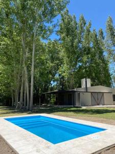 a blue swimming pool in front of a house at Best Logde Valle de Uco , Mendoza .Casa Calma in Vista Flores
