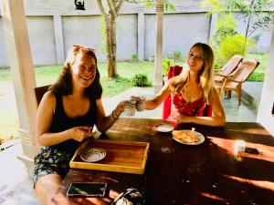 Bindu Homestay في ويلاوايا: كانتا جالستين على طاولة مع كوب من القهوة