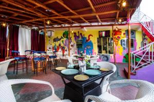 a room with a table and chairs and a colorful wall at Mountain Dew Guest House in Manāli