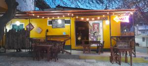 um restaurante com mesas e cadeiras em frente a um edifício amarelo em Hostel Villa Mary em Taganga