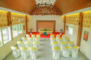 Kizhake ChālakudiAthirappilly Polaris Resort的一间设有黄色和白色椅子及桌子的房间