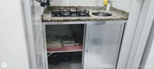 eine Küche mit einem Herd und einem Waschbecken in einem Schrank in der Unterkunft Temporada Copacabana Salu 1 in Rio de Janeiro