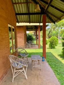 un patio con sillas, una mesa y un techo en Wild Breeze, en Tissamaharama