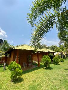 une maison avec un palmier en face dans l'établissement Wild Breeze, à Tissamaharama