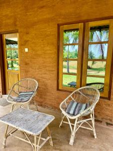 2 sillas y una mesa en un porche con ventanas en Wild Breeze, en Tissamaharama