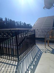 a fence on top of a building with a bench at Hotel Sansar Near Mall Road in Shimla
