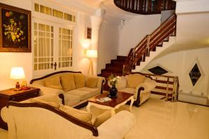 a living room with two couches and a staircase at Kandy view resort in Kandy