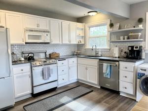 a kitchen with white cabinets and white appliances at Modern 2 Bedroom Farmhouse Cottage with Hot Tub in Snohomish in Snohomish