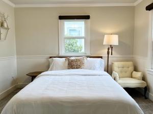 um quarto com uma cama, uma cadeira e uma janela em Modern 2 Bedroom Farmhouse Cottage with Hot Tub in Snohomish em Snohomish