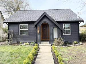 a black house with a brown door and a sidewalk at Modern 2 Bedroom Farmhouse Cottage with Hot Tub in Snohomish in Snohomish