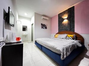 a bedroom with a bed and a tv in it at Little Chenang Cottage Motel Langkawi in Pantai Cenang