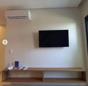 a flat screen tv hanging on a white wall at Salinas Premium Resort in Salinópolis