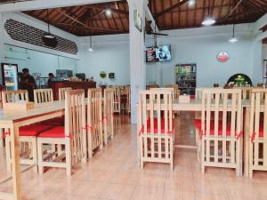 comedor con mesas y sillas de madera en Pandu Homestay Mandalika Lombok, en Kuta Lombok