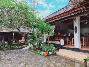 una casa con muchas plantas delante de ella en Pandu Homestay Mandalika Lombok, en Kuta Lombok