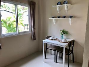 a white table and chairs in a room with a window at Wanpratheep Village Kohphangan in Ban Madua Wan