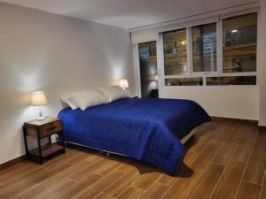 a bedroom with a blue bed and a window at Venue Studios in Lima