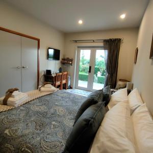 ein Wohnzimmer mit einem Sofa und einer Glasschiebetür in der Unterkunft Camcott Farm in Masterton