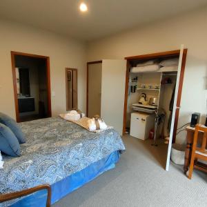 a bedroom with a large bed and a kitchen at Camcott Farm in Masterton