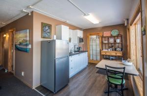 a kitchen with a refrigerator and a table and chairs at Aurora Bayside Inn in Yellowknife