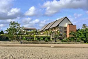 a building on the beach next to a beach at Swarga Suites Bali Berawa in Canggu