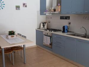 維拉普特祖的住宿－asfodelo，厨房配有蓝色橱柜、桌子和水槽