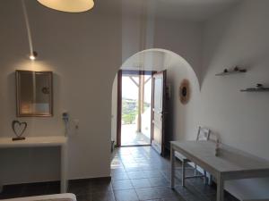 a dining room with a table and a hallway with a door at Marianthi Studios in Ano Meria