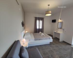 a bedroom with a bed and a couch and a sink at Marianthi Studios in Áno Meriá