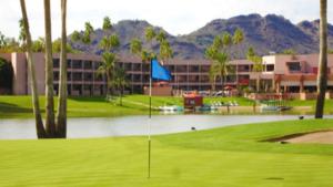 a golf course with a lake in front of a building at 10 Room ScottsdaleResortVillas by AmericanVacationliving in Scottsdale