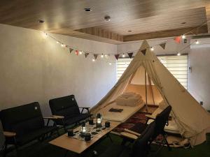 um quarto com uma tenda, cadeiras e uma mesa em TOCORO. Mt.Fuji Station HOSTEL Kawaguchiko em Fujikawaguchiko