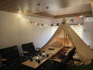 a room with a tent and chairs and a table at TOCORO. Mt.Fuji Station HOSTEL Kawaguchiko in Fujikawaguchiko