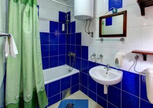 a blue and white bathroom with a sink and a tub at Villa Botticelli in Mostar