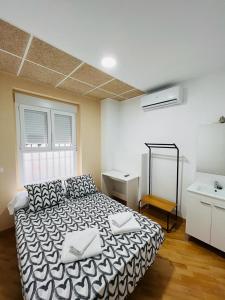 a bedroom with a bed and a desk in it at Hospedaje Puente de Vallecas in Madrid