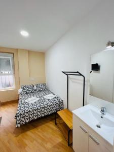 a room with a bed and a sink in it at Hospedaje Puente de Vallecas in Madrid