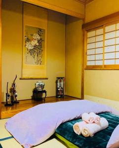 una camera da letto con un letto con asciugamani sopra di Nakao Villa (ナカオヴィラ） a Nozawa Onsen Altre 112 foto