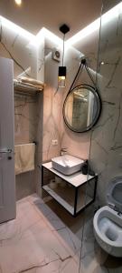uma casa de banho com um lavatório, um espelho e um WC. em LUXURY DRIJON APARTMENTS 3j em Shkodër
