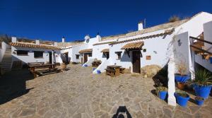 a courtyard of a white building with potted plants at Cuevas Barrio Las Santas in Huéscar