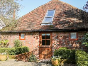 a brick house with a window and a door at The Old Granary in Pulborough