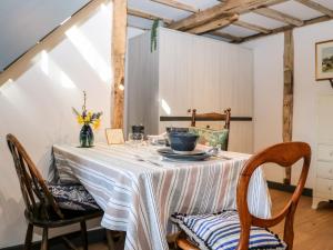 a dining room table with a white table cloth and chairs at The Old Granary in Pulborough