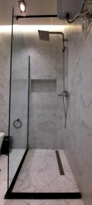 a shower in a bathroom with a marble wall at LUXURY DRIJON APARTMENTS 4d in Shkodër