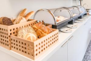 a tray of breads and pastries on a counter at Kolorowe Pola Boutique B&B in Polanica-Zdrój