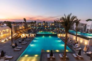 uma vista sobre uma piscina com cadeiras e palmeiras em Sunrise Tucana Resort Grand Select- em Hurghada