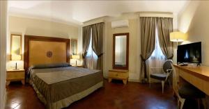 a bedroom with a bed and a desk and a television at Villa dei Tigli 920 Liberty Resort in Rodigo