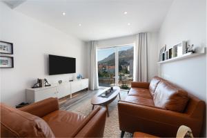- un salon avec deux canapés en cuir et une télévision dans l'établissement Helikon, à Dubrovnik