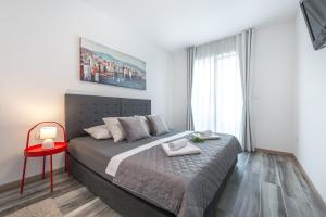 - une chambre avec un grand lit et un tabouret rouge dans l'établissement Helikon, à Dubrovnik
