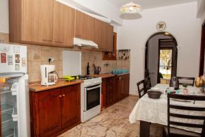a kitchen with wooden cabinets and a white stove top oven at City center, sea view apartment, Amelia! in Anemómylos