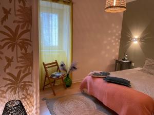 a bedroom with a bed and a chair and a window at Lovely apartment in Périgueux in Périgueux