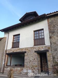 uma antiga casa de pedra com janelas em Casa con encanto en La Hayuela, situada a 5 min de Comillas em Udias