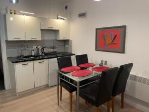 a kitchen with a table with red plates on it at Wakacyjny Dom na wyłączność "APARTAMENT LE SOLEIL" in Orzyny